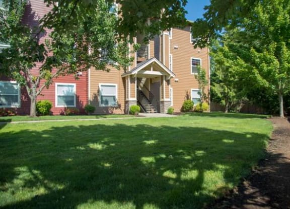 a large lawn in front of a brick house