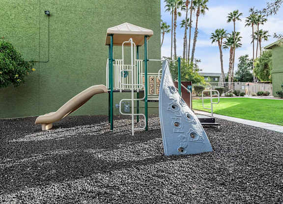 A playground with a slide and a climbing frame.