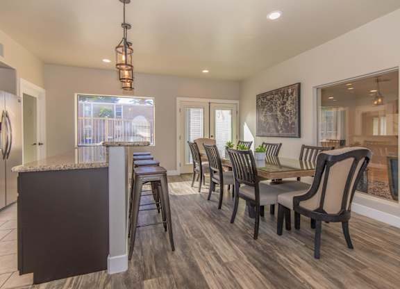 A kitchen with a bar and chairs.