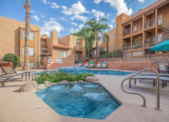 A pool surrounded by a patio with chairs and umbrellas.
