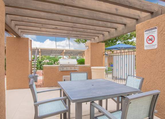 A patio with a table and chairs under a roof.