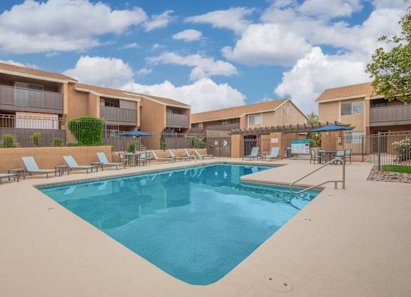 A large swimming pool in front of apartment buildings.