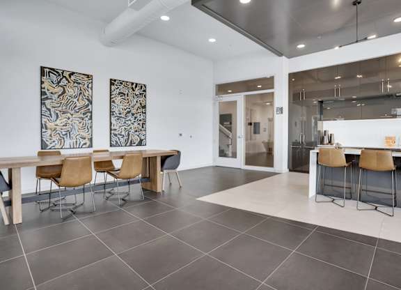A modern dining room with a long table and chairs.