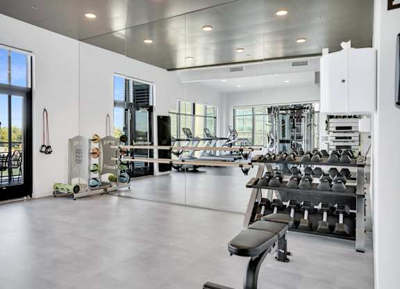 A gym with a variety of equipment including weights and machines.