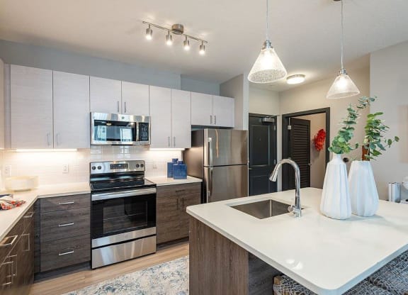 a kitchen with a sink stove refrigerator and microwave