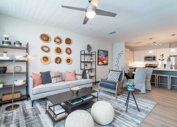 a living room filled with furniture and a ceiling fan