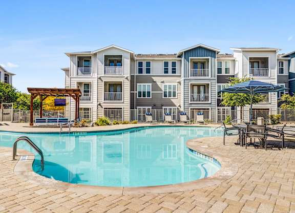 A swimming pool in front of apartment buildings.