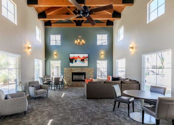 A spacious living room with a fireplace and a ceiling fan.