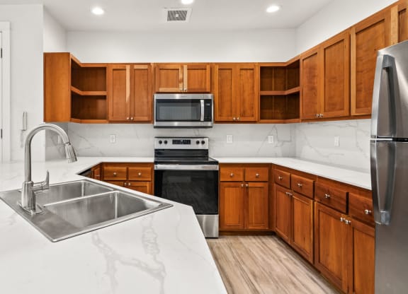 a large kitchen with wooden cabinets and stainless steel appliances