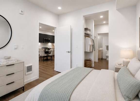 A bedroom with a large bed and a mirror on the wall.