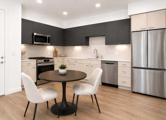 A modern kitchen with a round table and chairs.