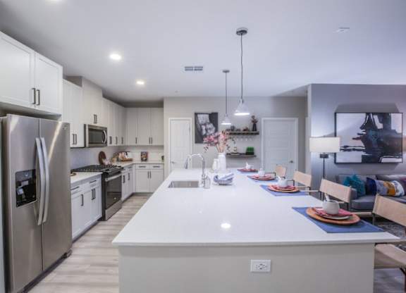 A modern kitchen with a large island and stainless steel appliances.