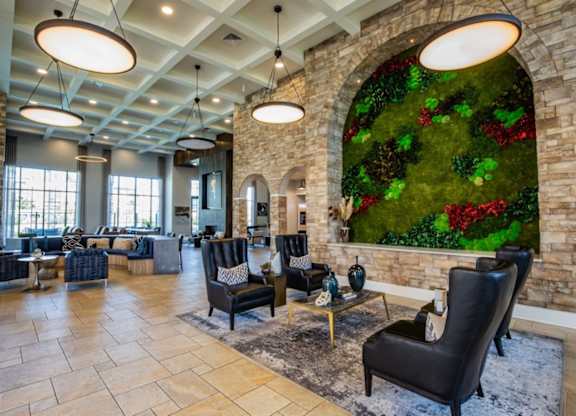 A living room with a green wall and black chairs.