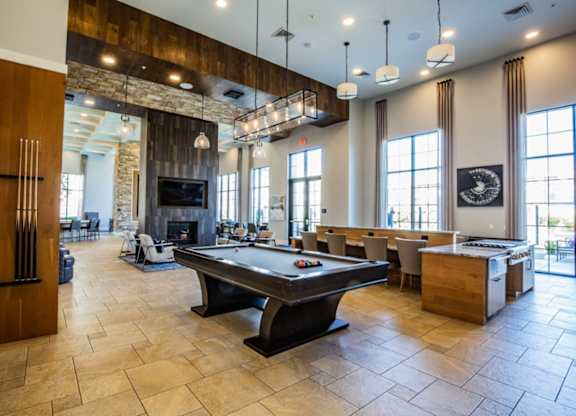A large room with a pool table and a fireplace.