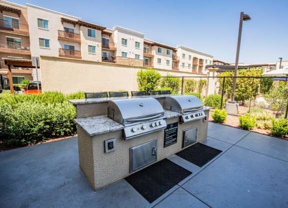 A BBQ grill is in the middle of a patio.