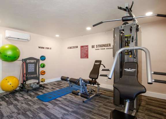 A gym with a variety of equipment including a leg press machine.