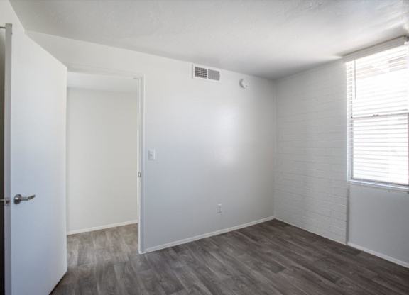 A room with a white door and a window with blinds.