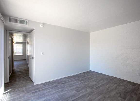 A room with a white wall and wooden floor.