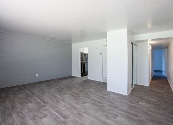 A room with wooden flooring and white walls.