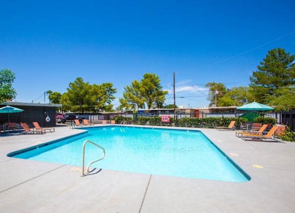 A large swimming pool with a diving board and lounge chairs.