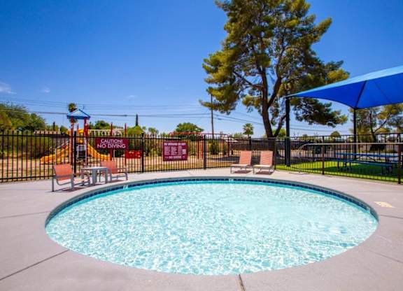 A round blue pool with a black fence around it.