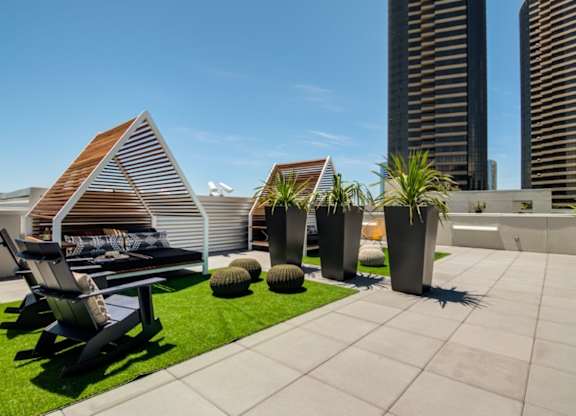 A patio with a chair and a table with a striped awning.