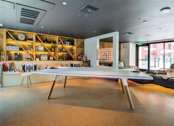 A room with a long table and shelves with various items on them.