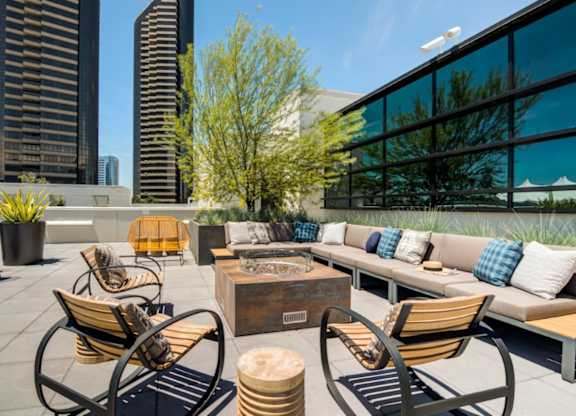 A modern outdoor seating area with wooden furniture and a view of the city skyline.