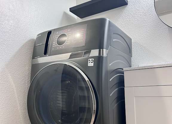 A modern washing machine is placed in a laundry room.