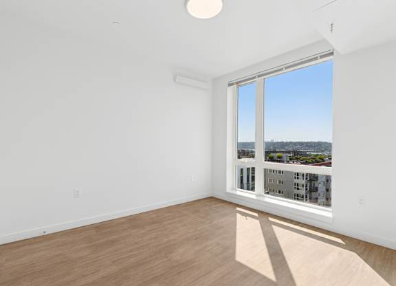 A room with a large window overlooking a cityscape.