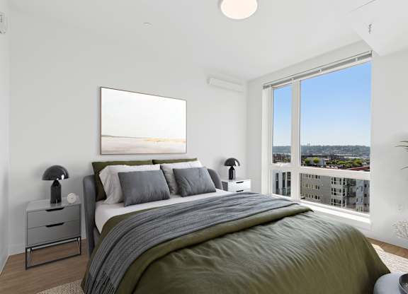 A bedroom with a large bed and a view of the city.