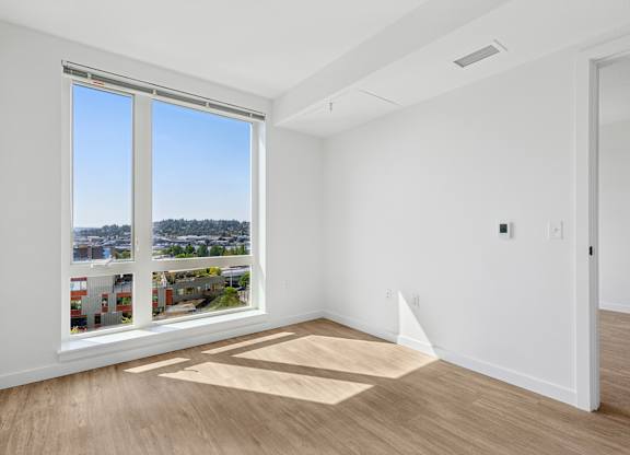 A room with a large window overlooking a cityscape.