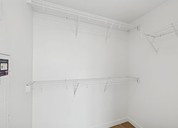 Empty white room with shelves on the wall.