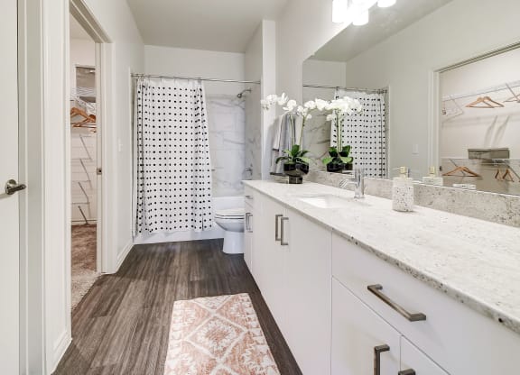 The Dylan  bathroom with white cabinets and a white shower curtain