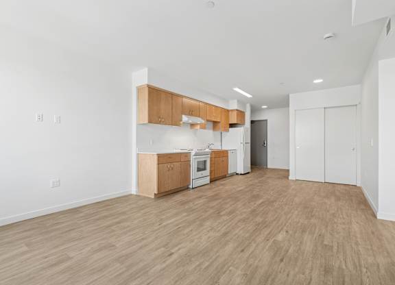 A kitchen area with wooden floors and white walls.
