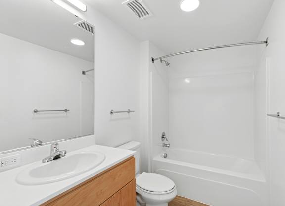 A white bathroom with a sink, toilet, and bathtub.