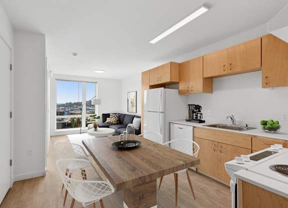 A kitchen with a table and chairs in front of a window.