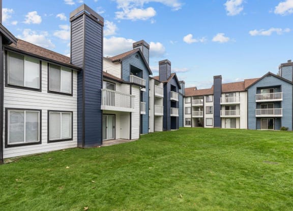 a row of townhomes with green grass in front