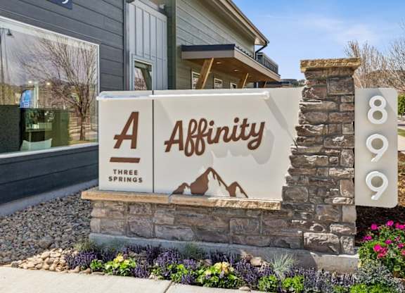 A sign for Affinity Three Springs is in front of a house.