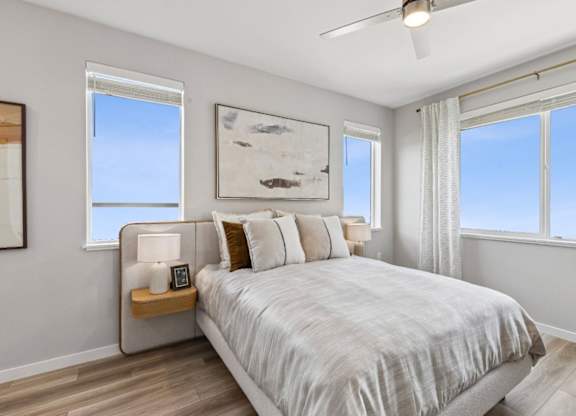 A bedroom with a large bed and a ceiling fan.