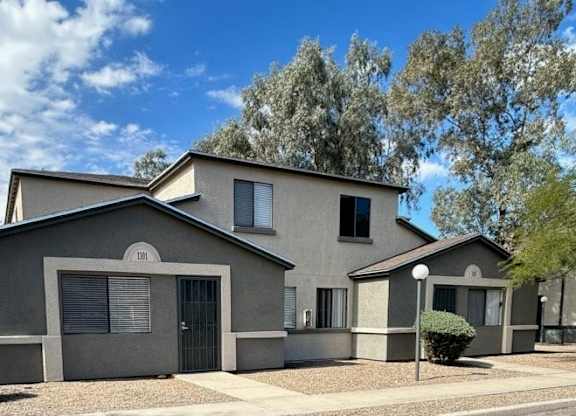 A modern house with a grey exterior and a black gate.