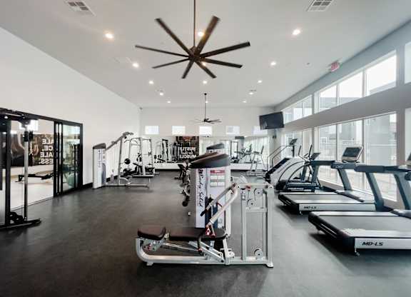 A gym with treadmills, weights, and exercise equipment.