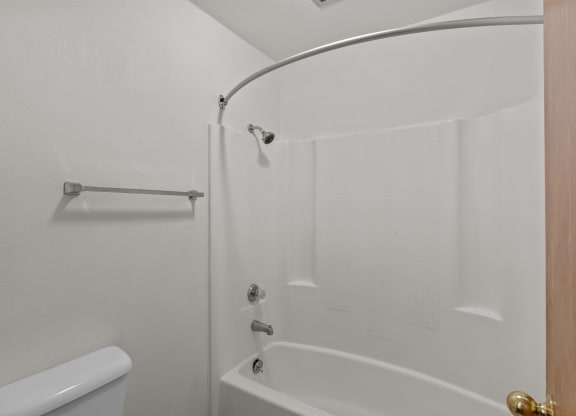 a white bathroom with a shower and a toilet