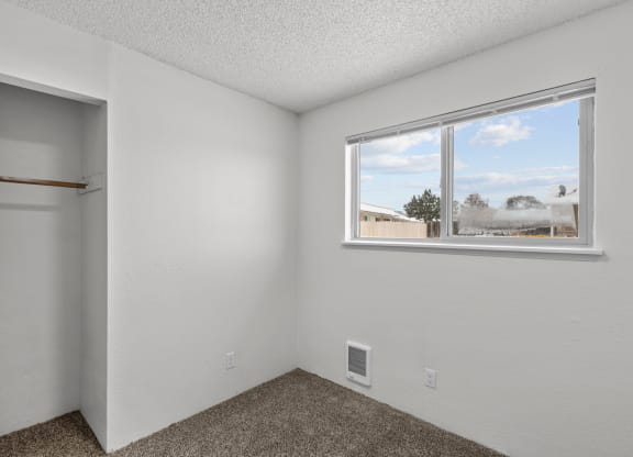 the living room of an apartment with a window and a closet
