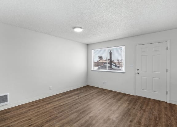 Creekside Apartments empty living room with white walls and wood flooring