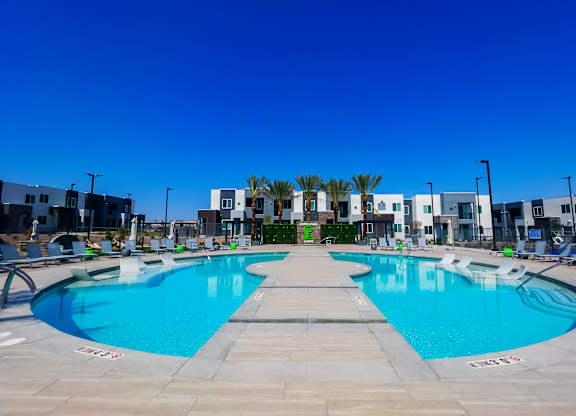 A large outdoor swimming pool with a building in the background.