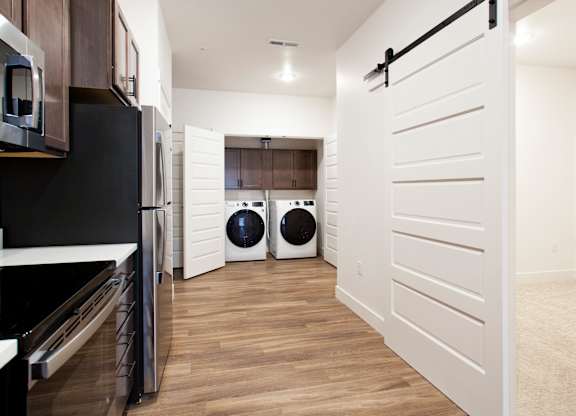 A white door is open in a modern kitchen.