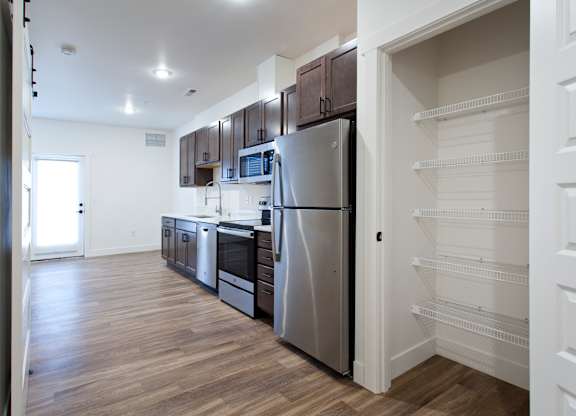 A kitchen with a refrigerator, microwave, and oven.