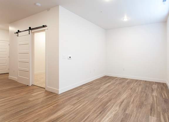A room with a sliding door and wood flooring.