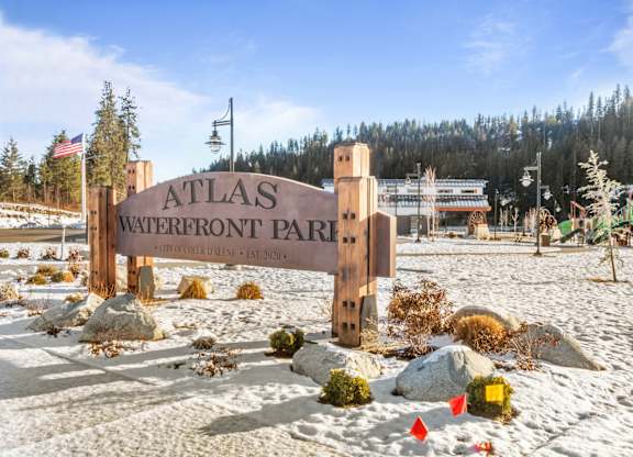 a sign that reads atlas westfront park with a playground in the background